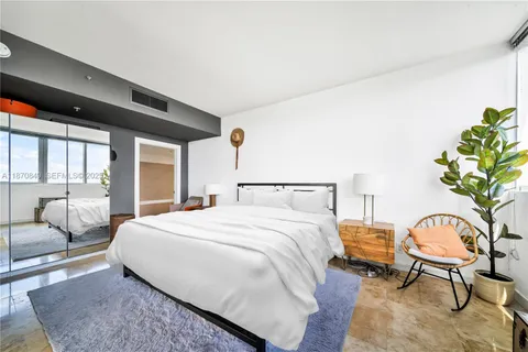 a bedroom with a bed chair and window