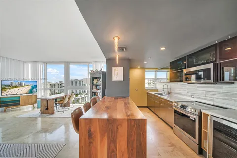 a large living room with stainless steel appliances kitchen island granite countertop a large kitchen counter top a stove and a sink with couches