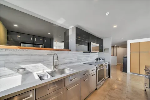 a kitchen with stainless steel appliances granite countertop a sink and a refrigerator