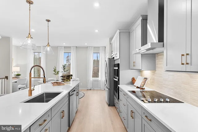 a kitchen with stainless steel appliances kitchen island granite countertop a refrigerator and a stove top oven