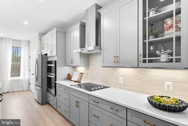 a kitchen with stainless steel appliances granite countertop a stove a refrigerator a kitchen island a table and chairs