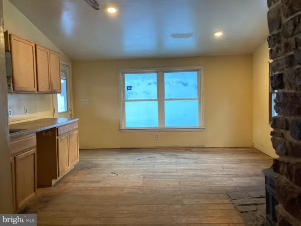 a view of an empty room with a kitchen