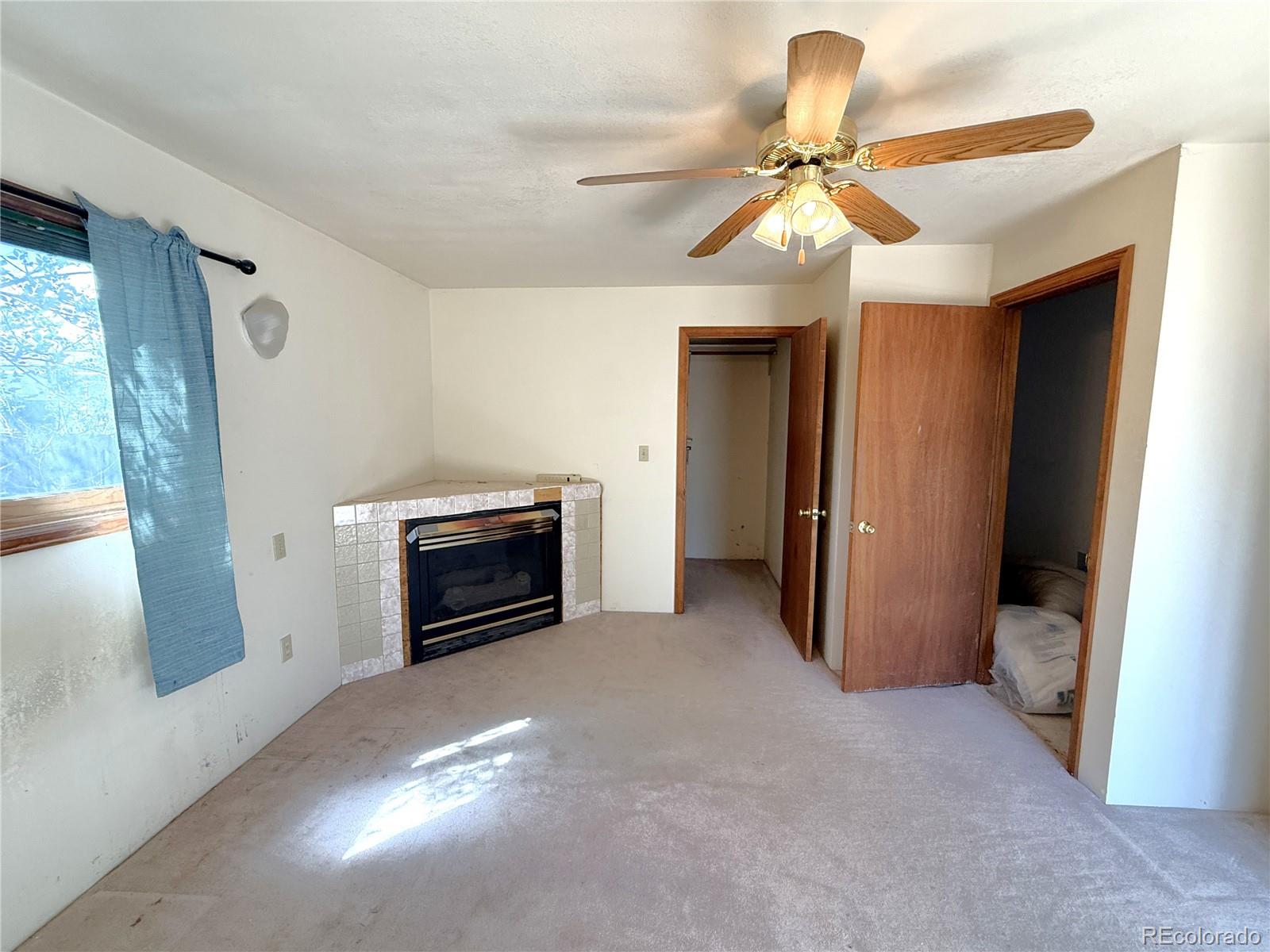 426 3rd Street Hugo, CO 80821 - Photo 15 of 34 a view of a livingroom with a fireplace a ceiling fan and wooden floor