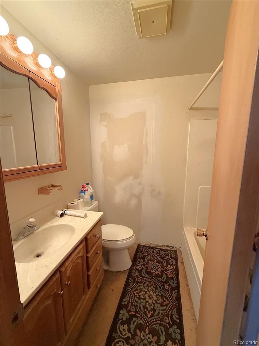 426 3rd Street Hugo, CO 80821 - Photo 19 of 34 a bathroom with a sink a toilet a shower and a mirror