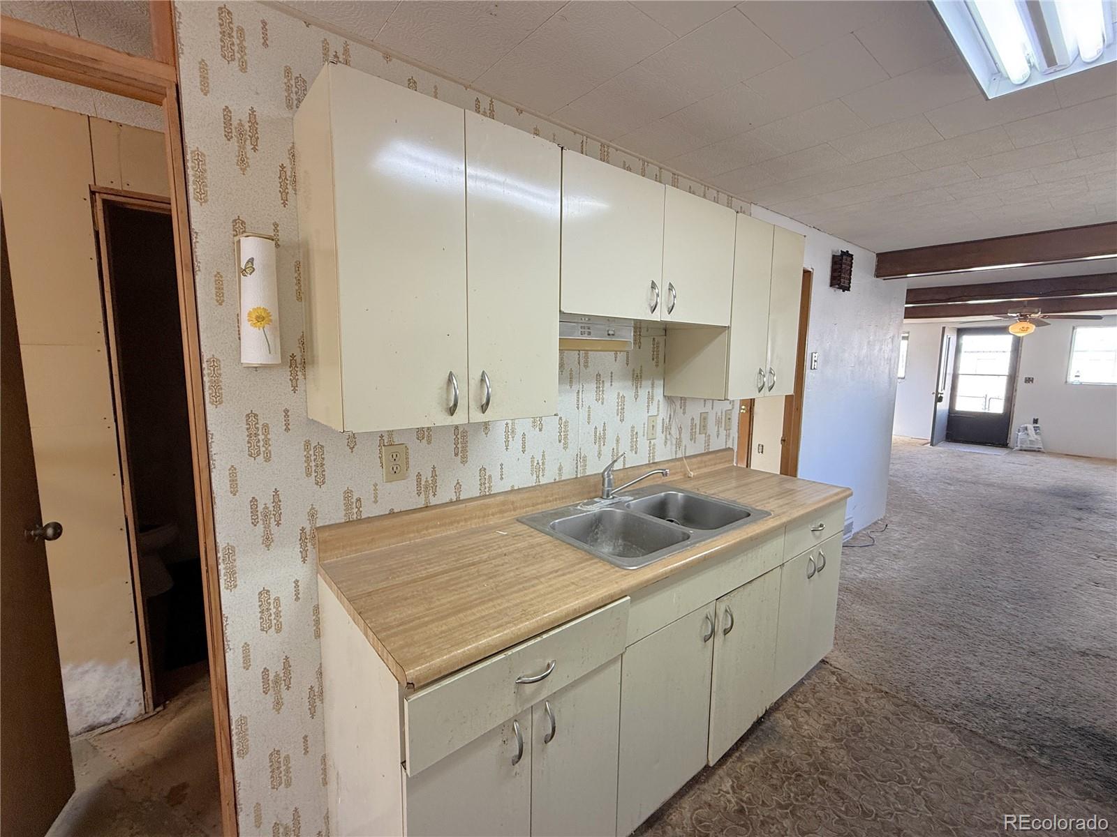 426 3rd Street Hugo, CO 80821 - Photo 7 of 34 a kitchen with a sink and a refrigerator