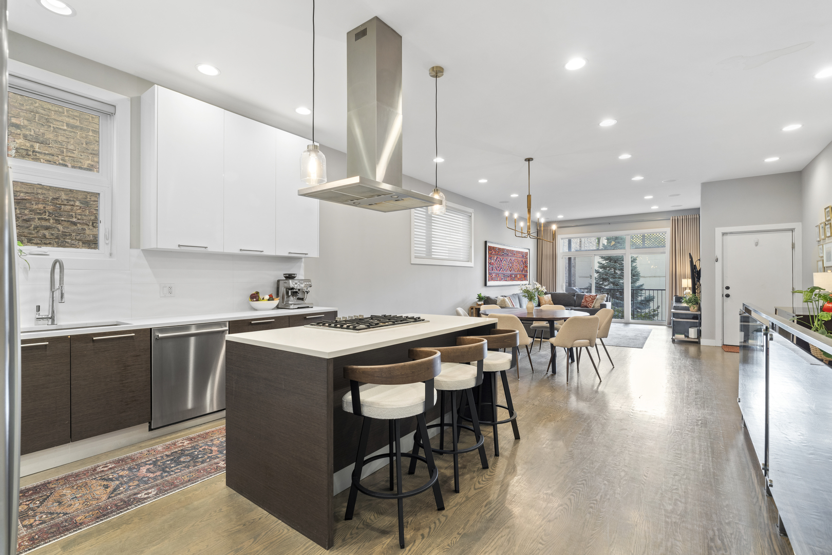 878 North Marshfield Avenue, Unit 1 Chicago, IL 60622 - Photo 8 of 26 a kitchen with stainless steel appliances granite countertop a stove a refrigerator a kitchen island a dining table and chairs with wooden floor