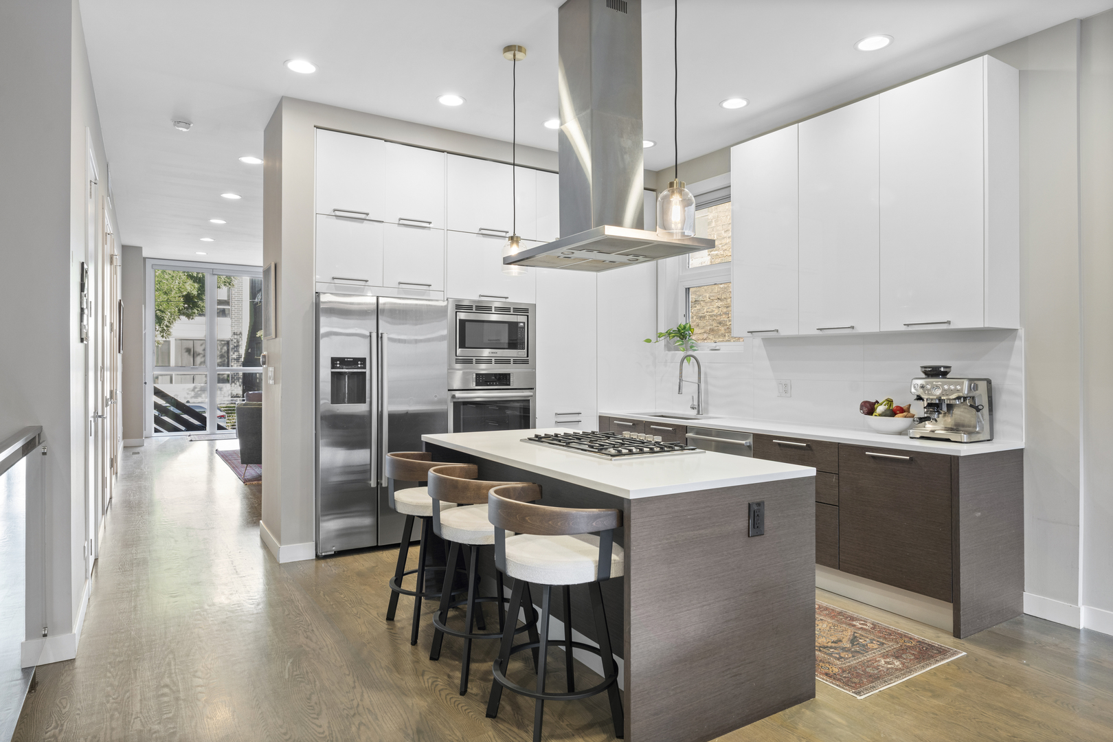 878 North Marshfield Avenue, Unit 1 Chicago, IL 60622 - Photo 9 of 26 a kitchen with stainless steel appliances granite countertop a stove a refrigerator a sink dishwasher and a dining table with wooden floor