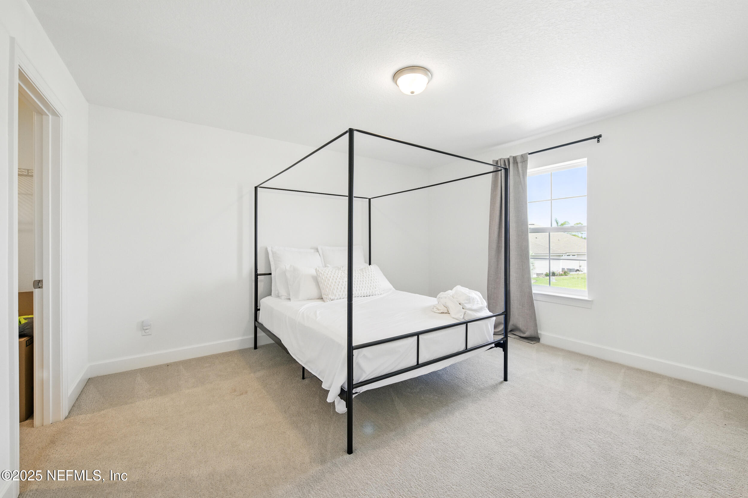 177 Windwalker Drive St. Augustine, FL 32092 - Photo 22 of 30 a white bed sitting in a room next to a window