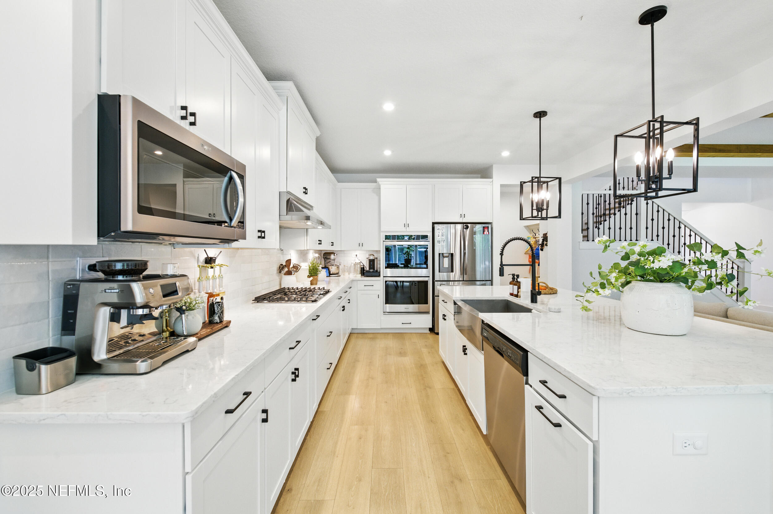 177 Windwalker Drive St. Augustine, FL 32092 - Photo 9 of 30 a kitchen with stainless steel appliances kitchen island granite countertop a sink a stove and a wooden floors