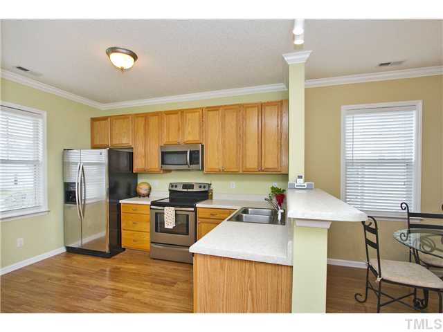 1023 Dual Parks Road Apex, NC 27502 - Photo 3 of 16 Kitchen features breakfast bar, 42" cabinets, pantry and stainless steel appliances! Appliances are less than 1 year old!