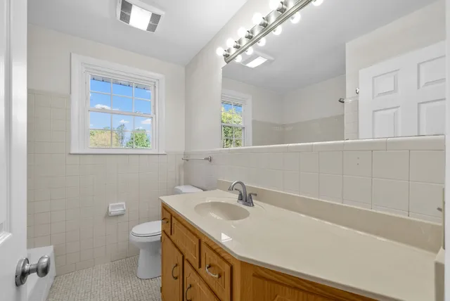 a bathroom with a sink a toilet and a mirror