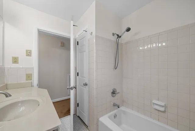 a bathroom with a tub a sink and shower