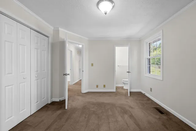 an empty room with windows and closet