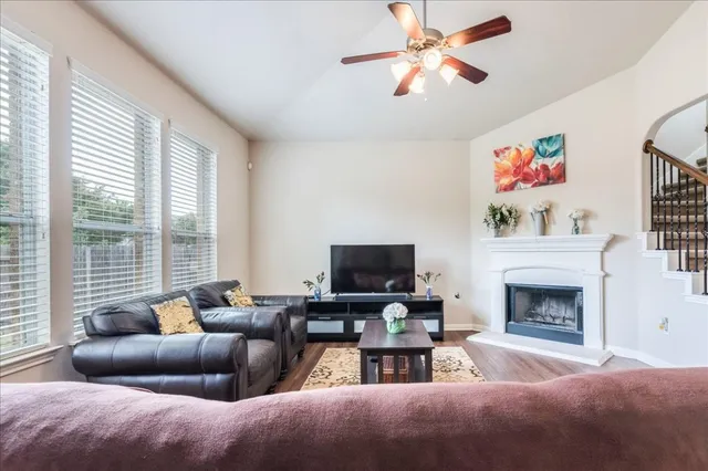a living room with furniture a fireplace and a flat screen tv