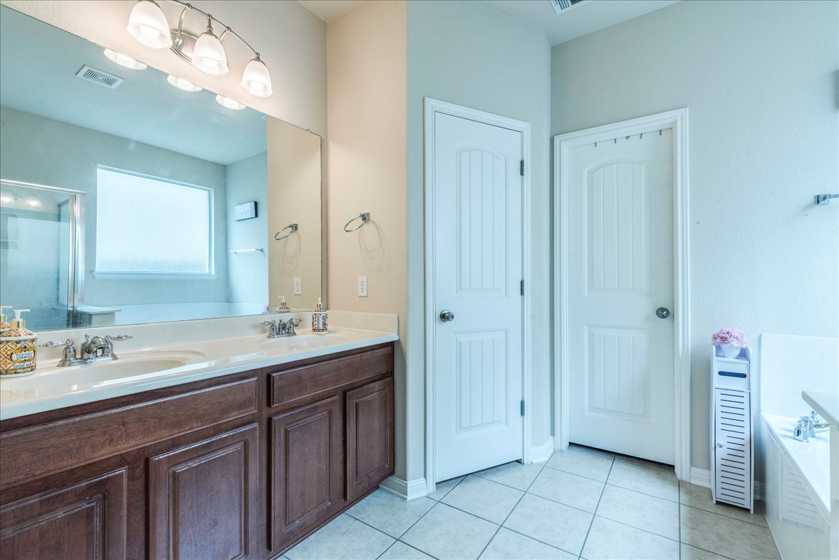18628 Wind Valley Way Pflugerville, TX 78660 - Photo 13 of 33 a bathroom with a sink and a mirror