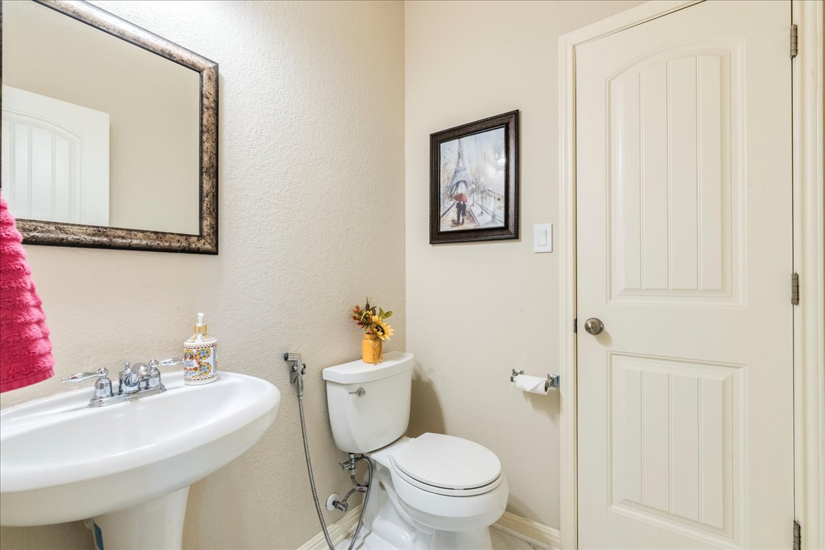 18628 Wind Valley Way Pflugerville, TX 78660 - Photo 14 of 33 a bathroom with a toilet a sink and mirror