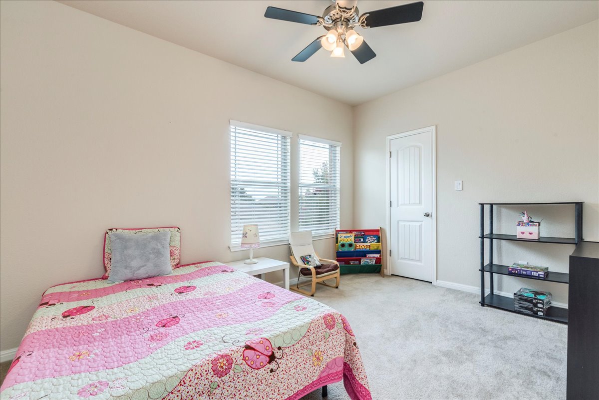 18628 Wind Valley Way Pflugerville, TX 78660 - Photo 16 of 33 a bedroom with a bed and furniture