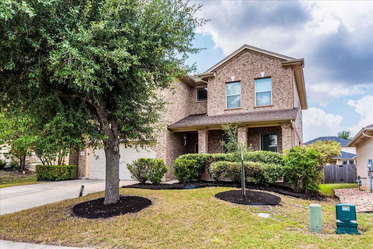 18628 Wind Valley Way Pflugerville, TX 78660 - Photo 2 of 33 a front view of a house with garden