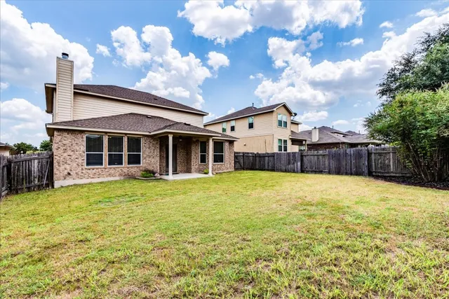 a view of a house with a backyard and a tree