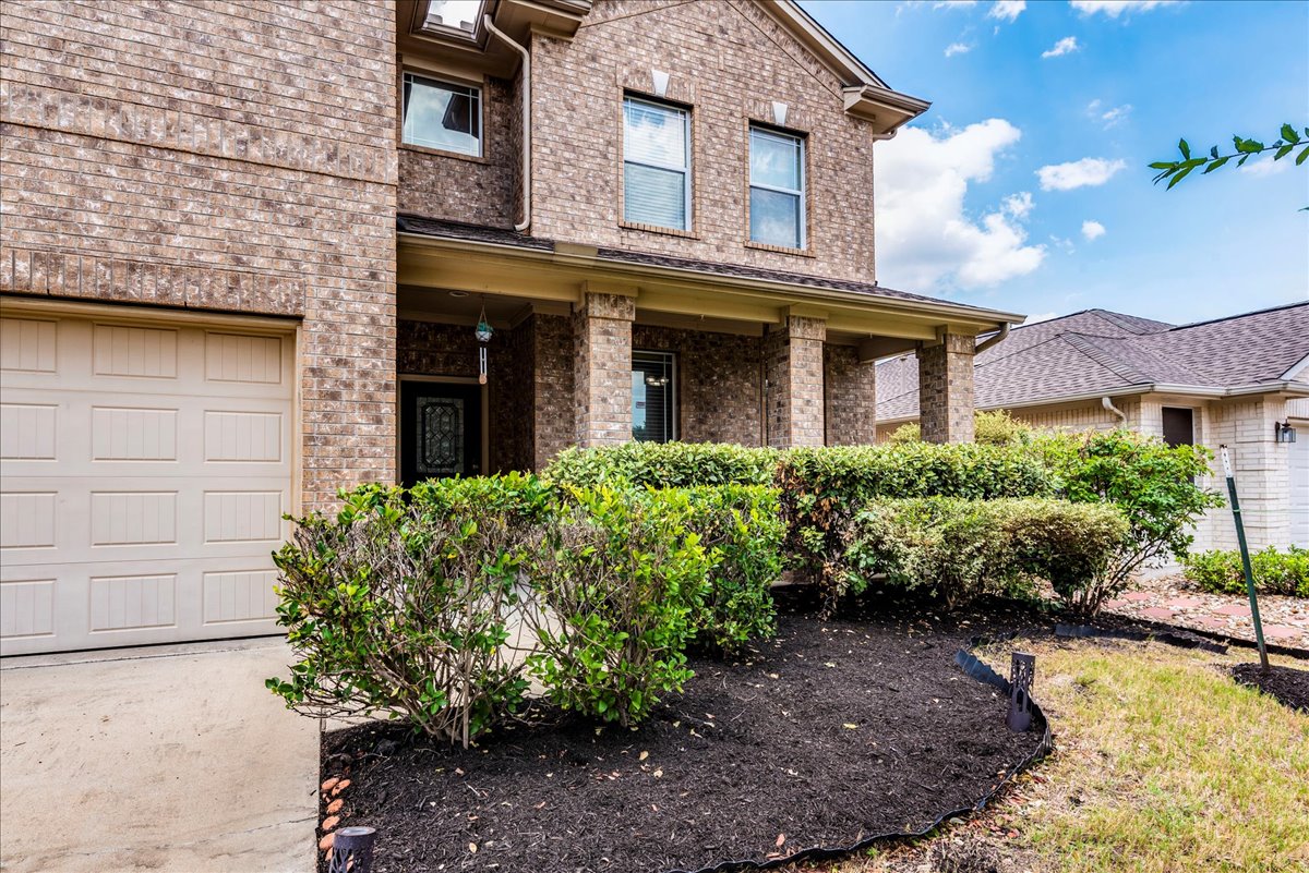 18628 Wind Valley Way Pflugerville, TX 78660 - Photo 4 of 33 a view of a house with brick walls and plants