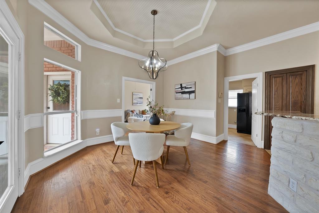 1110 McCampbell Road Mansfield, TX 76063 - Photo 13 of 39 a dining room with wooden floor a chandelier a glass table and chairs