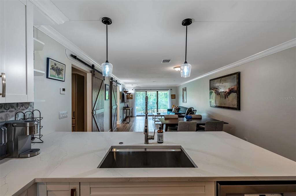 29147 Bay Hollow Drive, Unit 3224 Wesley Chapel, FL 33543 - Photo 12 of 89 a view of a kitchen with kitchen island stainless steel appliances a sink a counter top space and a view of living room