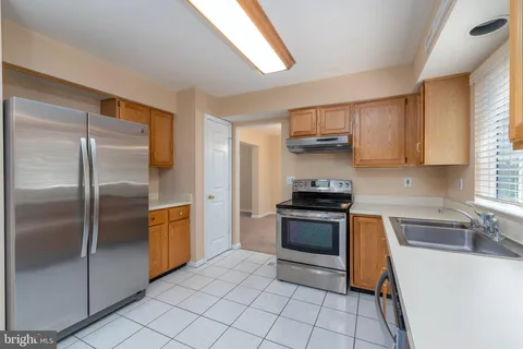 a kitchen with stainless steel appliances granite countertop a refrigerator sink and stove