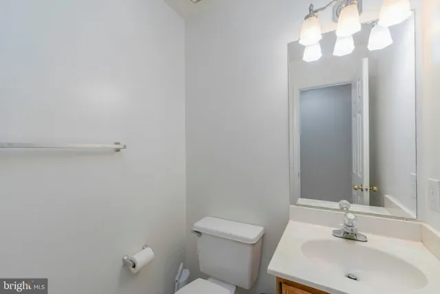a bathroom with a sink vanity mirror and toilet