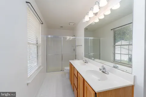 a bathroom with a double vanity sink mirror and shower