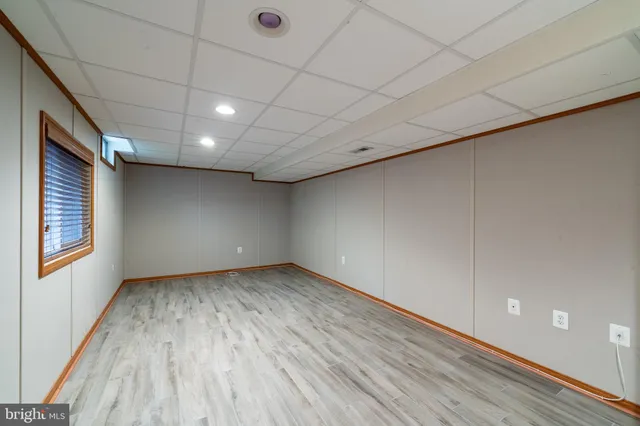 a view of an empty room with wooden floor and stairs