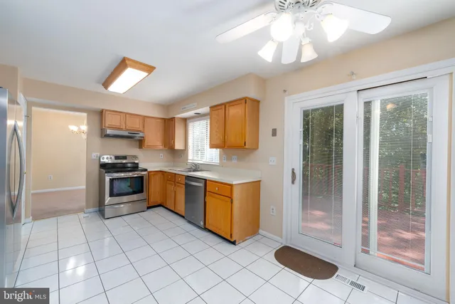 a large kitchen with a stove a sink dishwasher a refrigerator and a stove with wooden floor