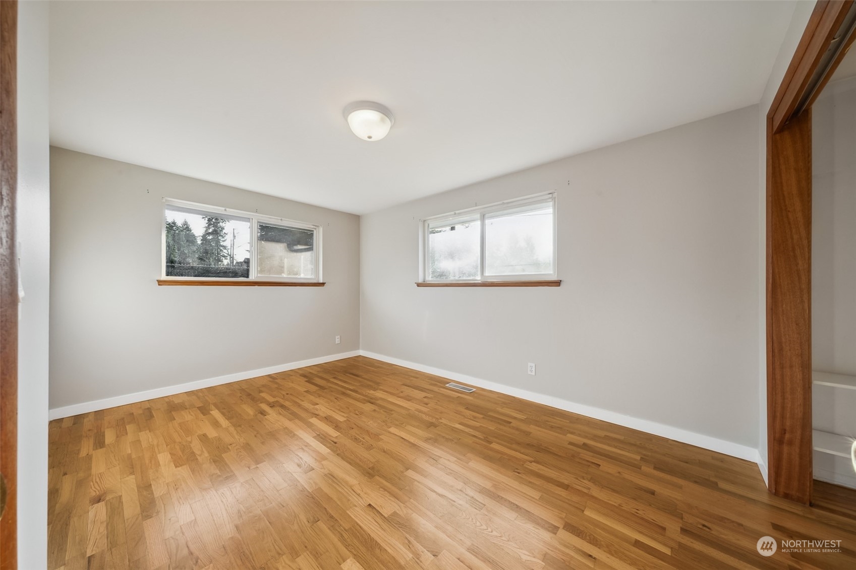 15044 Southeast 113th Street Renton, WA 98059 - Photo 12 of 26 a view of an empty room with wooden floor and a window