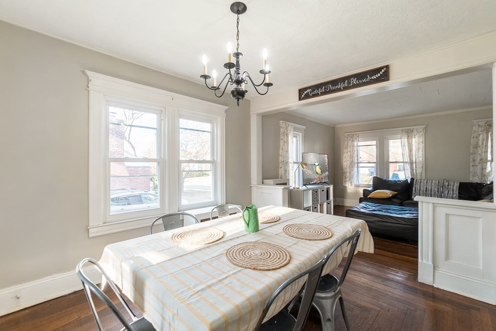 68 Abbott Street Springfield, MA 01118 - Photo 11 of 28 a dining room with wooden floor a chandelier a wooden table and chairs