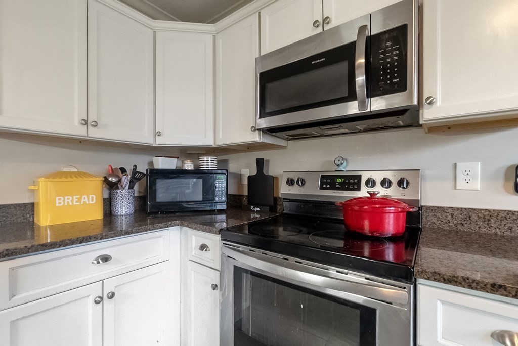 68 Abbott Street Springfield, MA 01118 - Photo 5 of 28 a kitchen with stainless steel appliances granite countertop a stove a microwave and cabinets
