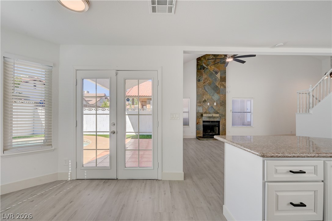 6505 Deadwood Road Las Vegas, NV 89108 - Photo 28 of 33 Patio doors open to a sun-drenched outdoor area, complementing the open-concept living space with a stately fireplace.
