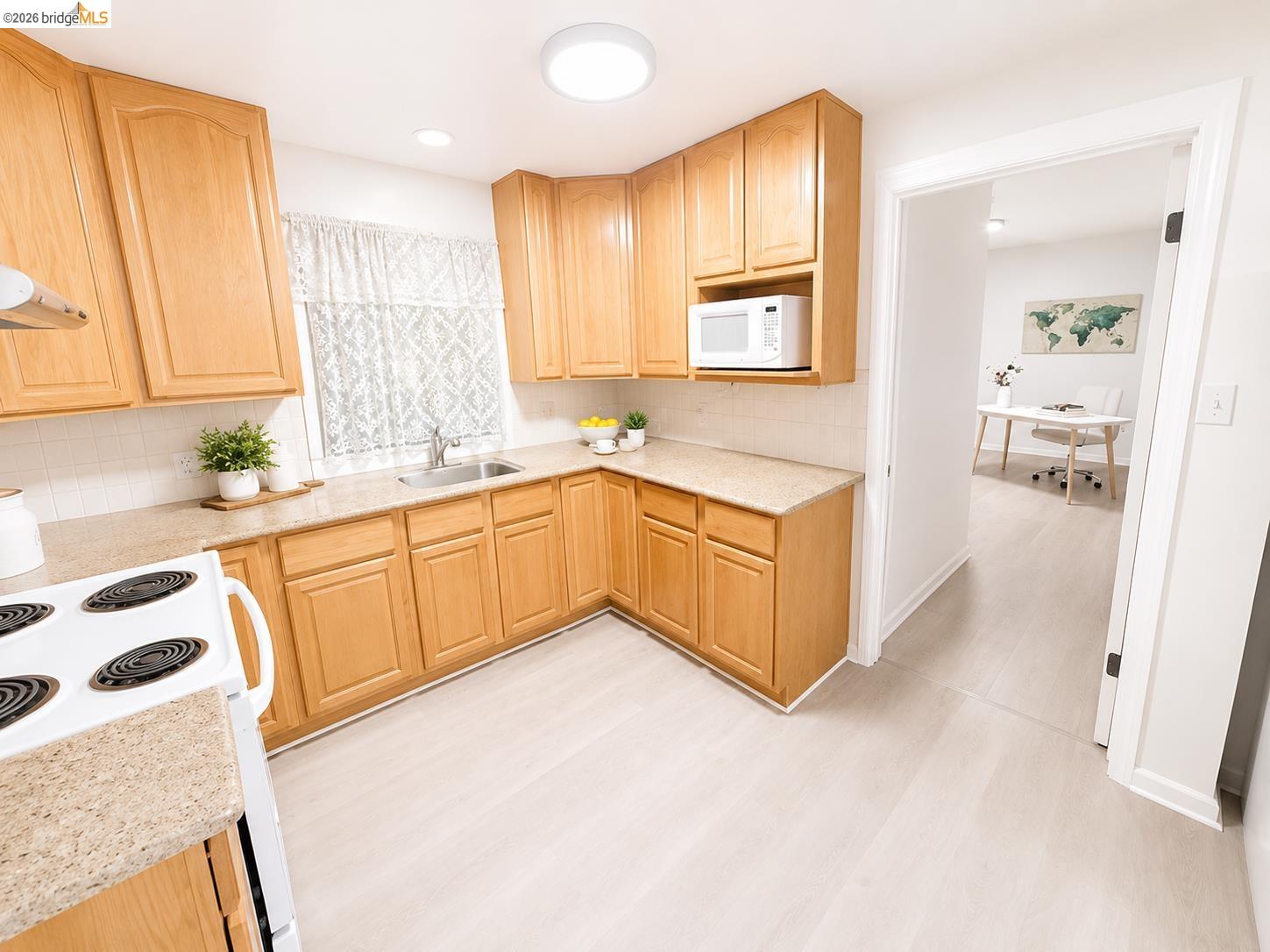810 Pierce Street Albany, CA 94706 - Photo 13 of 25 Kitchen featuring wood cabinetry, light-toned countertops, a white tile backsplash, and light wood-finish flooring