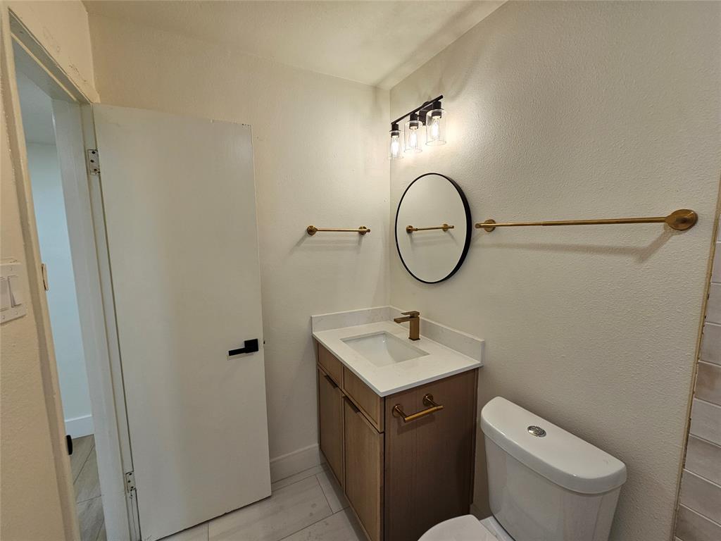 1725 R Avenue, Unit 1725 Plano, TX 75074 - Photo 11 of 20 Bathroom featuring a vanity with a white countertop, undermount sink, and gold-tone faucet