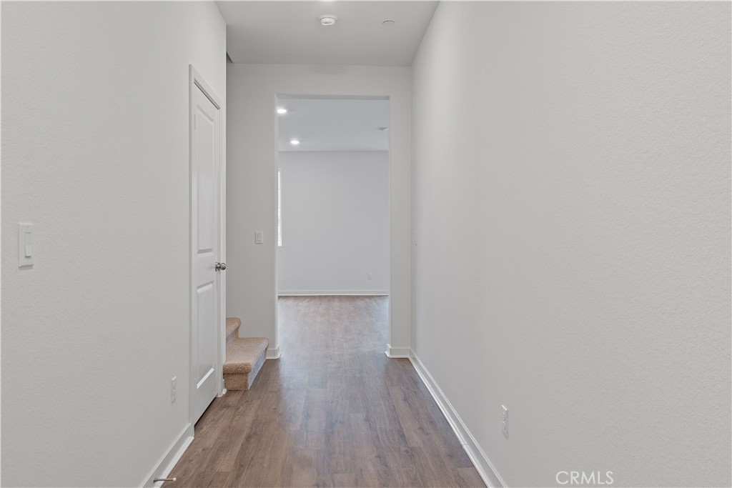 12764 Clifton Way Yucaipa, CA 92399 - Photo 9 of 24 a view of a hallway with wooden floor