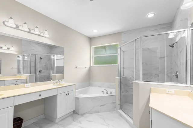 a bathroom with a bathtub shower sink and mirror