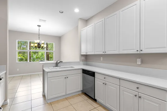 a kitchen with a white cabinets and window