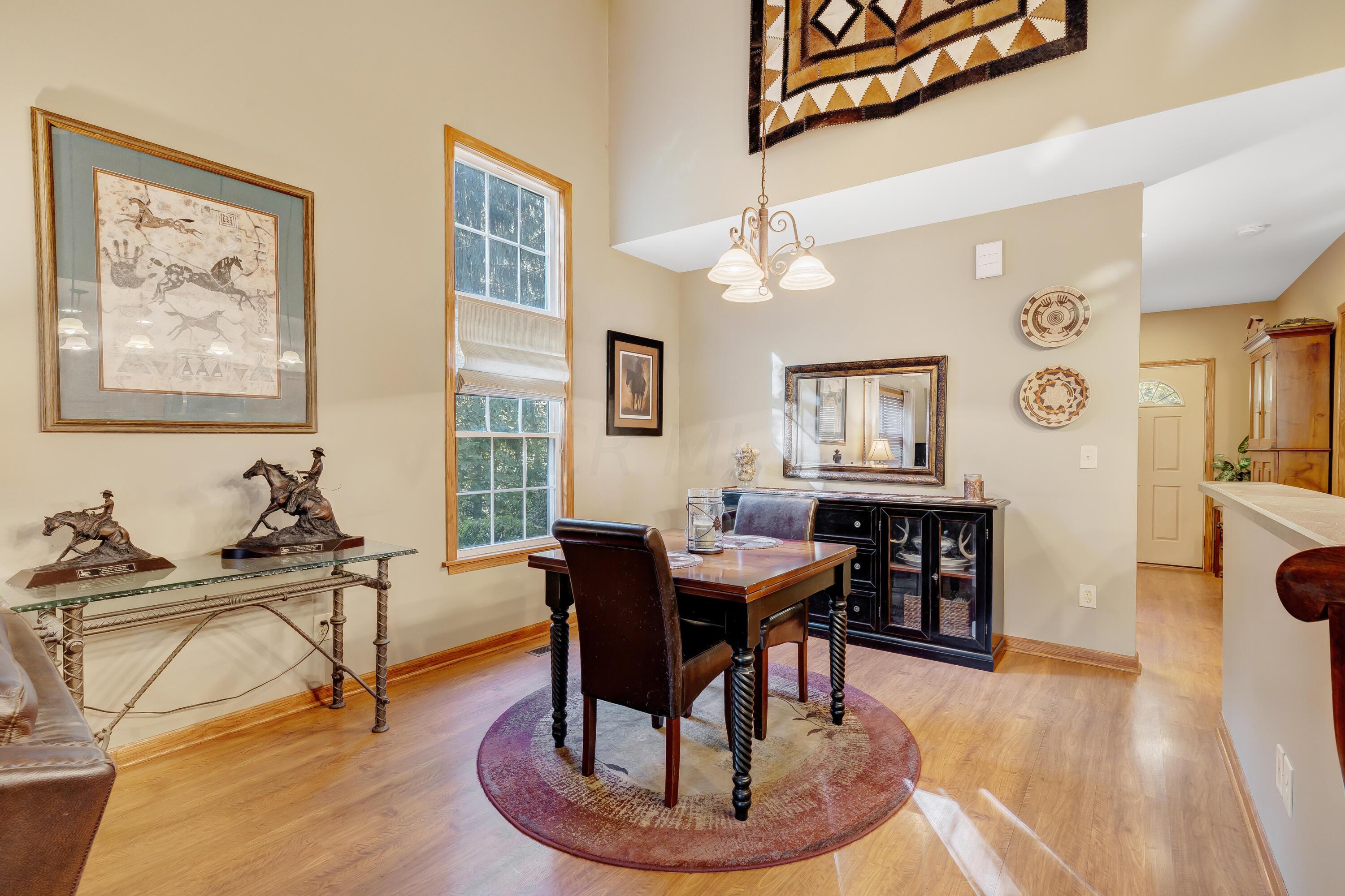 6681 Harlem Road Westerville, OH 43082 - Photo 10 of 78 • Laminate flooring • Tan painted walls • Hanging chandelier • Vaulted ceiling