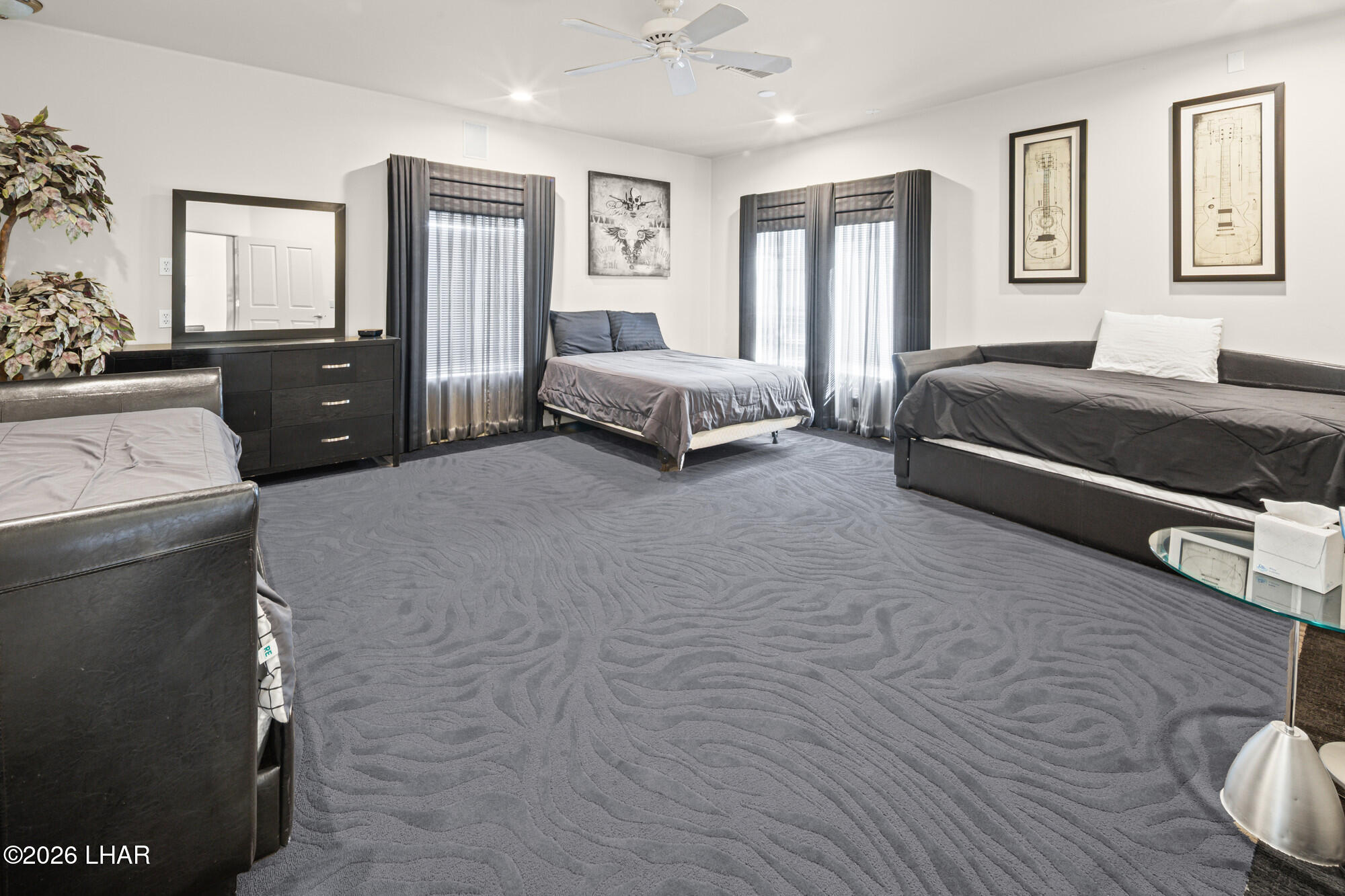 6674 Riverside Drive Parker, AZ 85344 - Photo 21 of 57 a spacious bedroom with a bed a couch and dresser