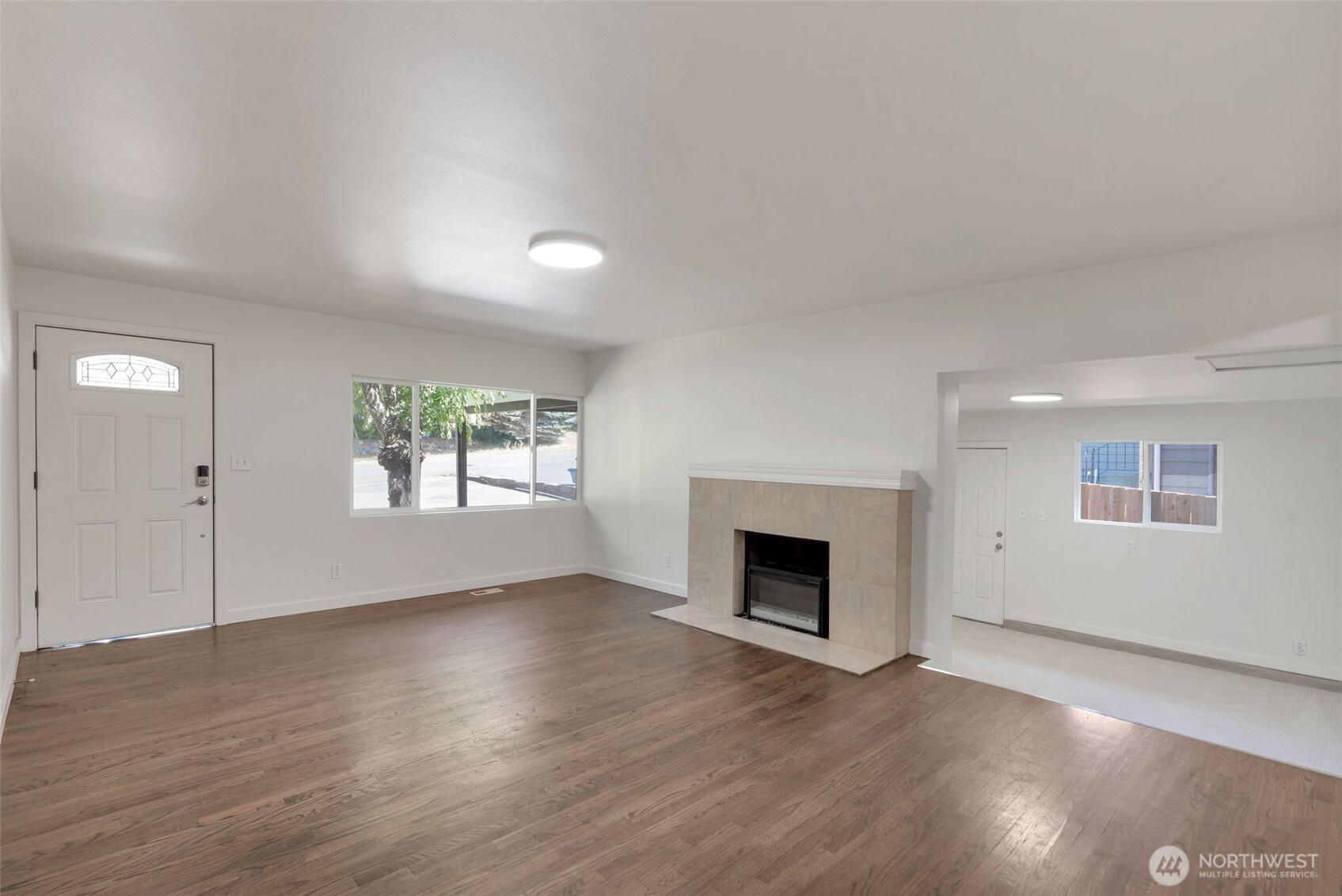 11229 29th Avenue Southwest Seattle, WA 98146 - Photo 4 of 28 an empty room with wooden floor a fireplace and windows
