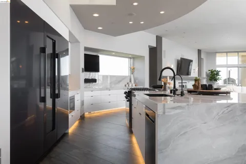a view of a kitchen with a sink and a refrigerator