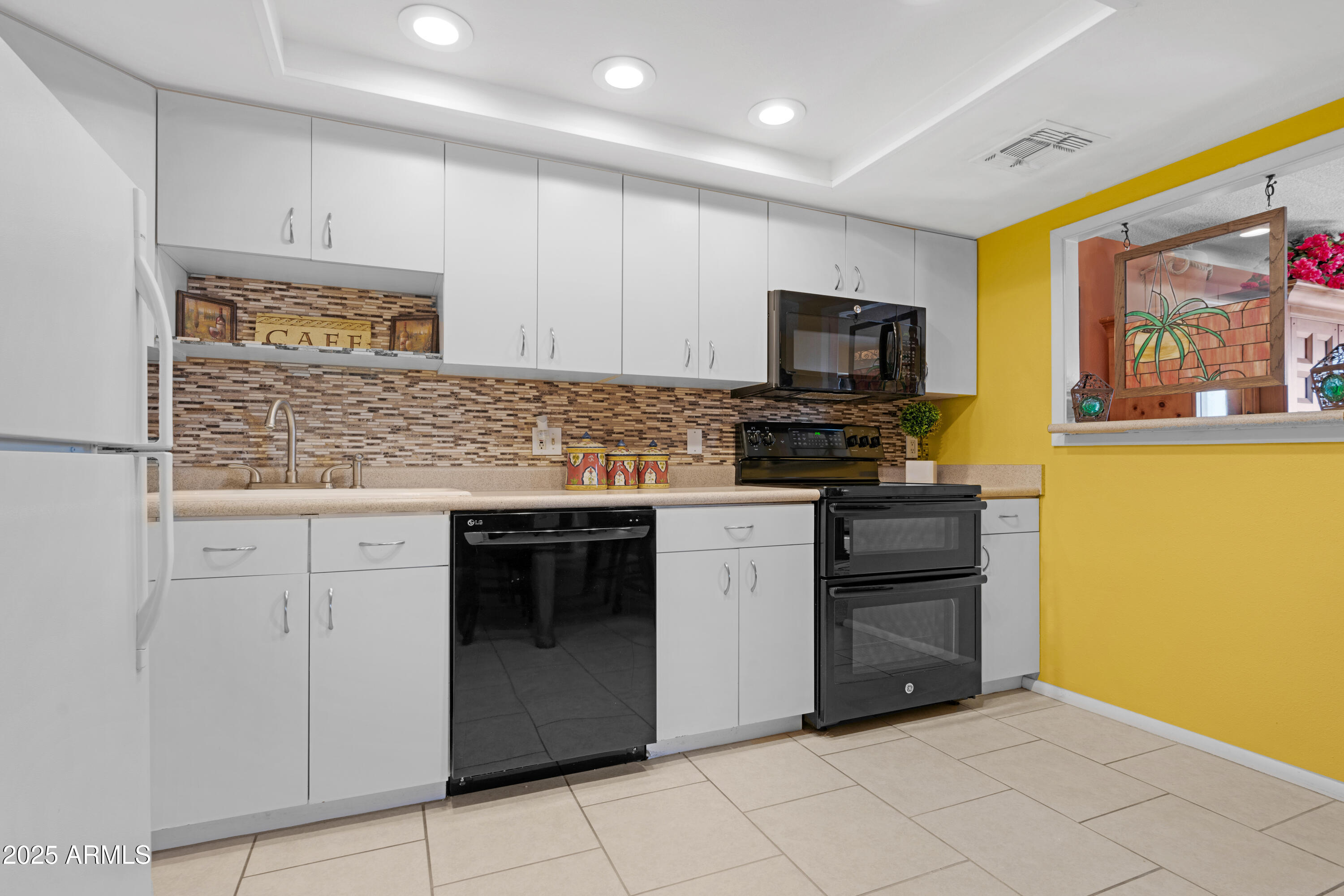 7820 East Camelback Road, Unit 510 Scottsdale, AZ 85251 - Photo 35 of 50 a kitchen with granite countertop a stove top oven microwave and cabinets