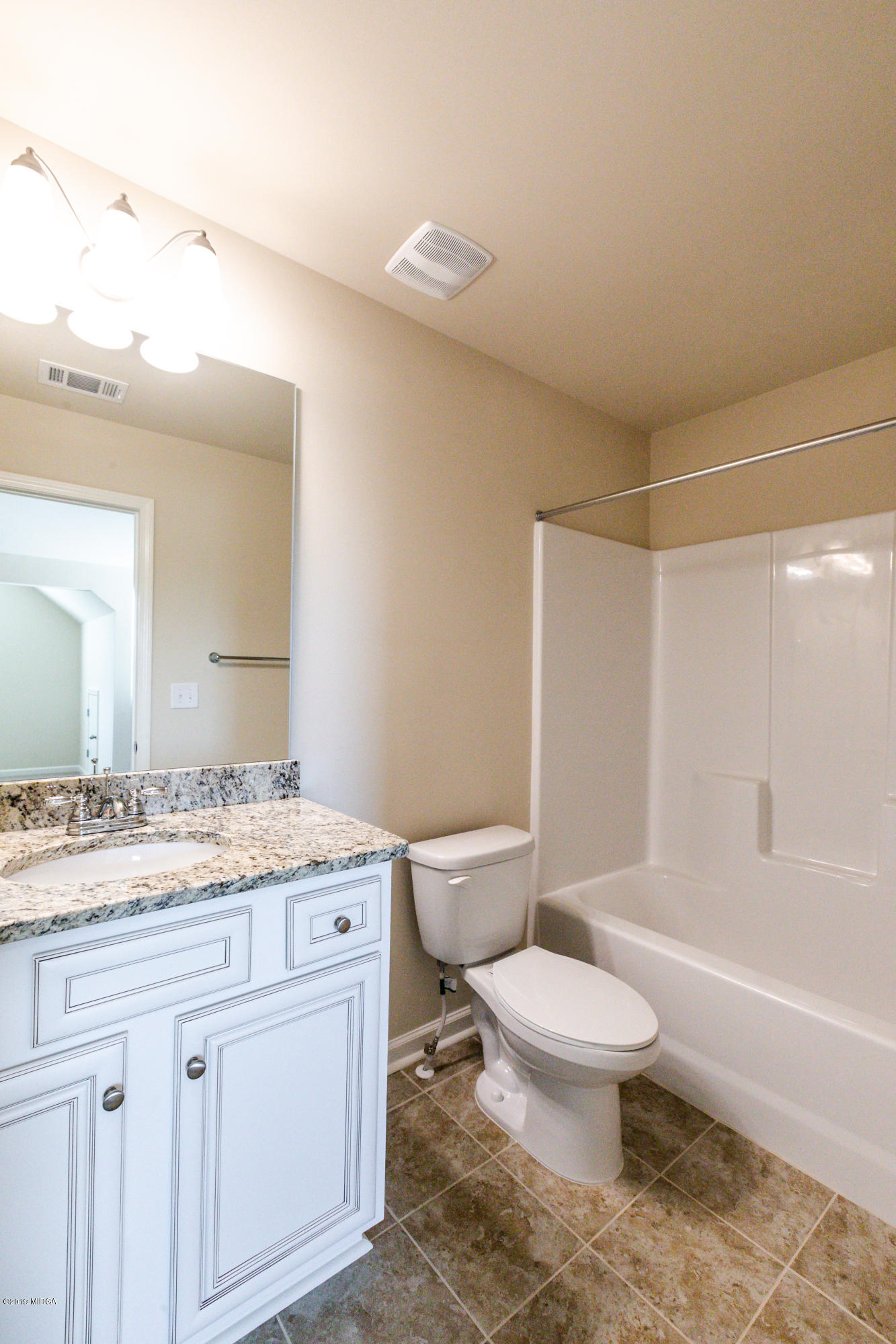 160 Homestead Circle Forsyth, GA 31029 - Photo 38 of 40 a bathroom with a granite countertop sink toilet a mirror and bathtub