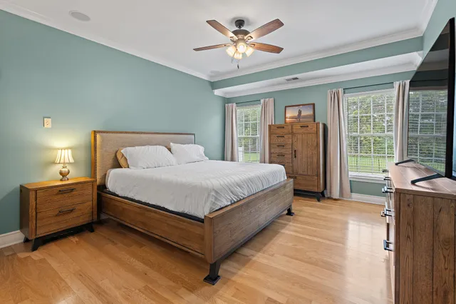a bedroom with a large bed and a chandelier