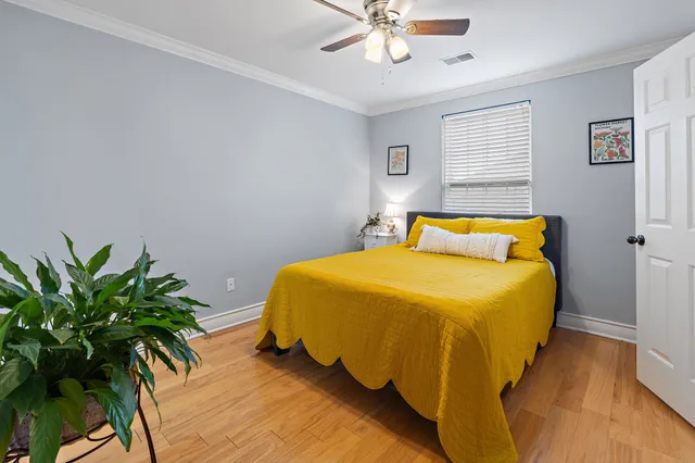 a bedroom with a bed and a potted plant