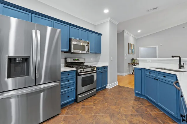 a kitchen with stainless steel appliances granite countertop a refrigerator stove and sink