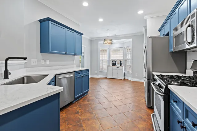 a kitchen with stainless steel appliances granite countertop a stove a sink and a refrigerator